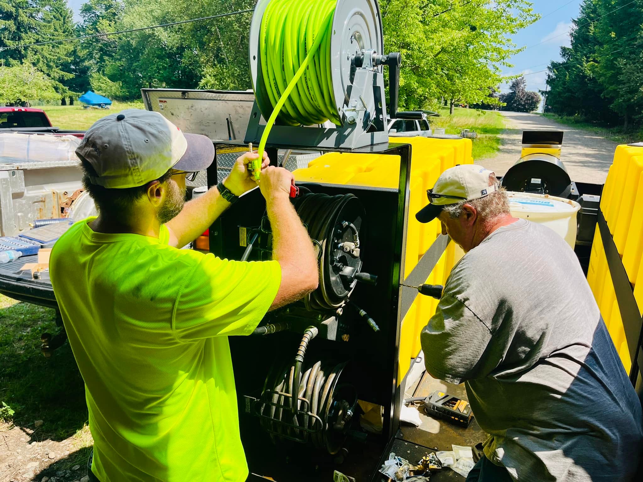 The Northern EcoWash crew working at their soft-wash rig and hose reel